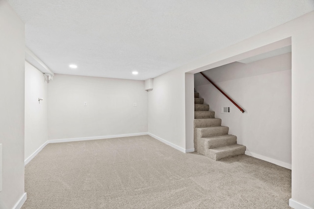 basement with carpet and a textured ceiling