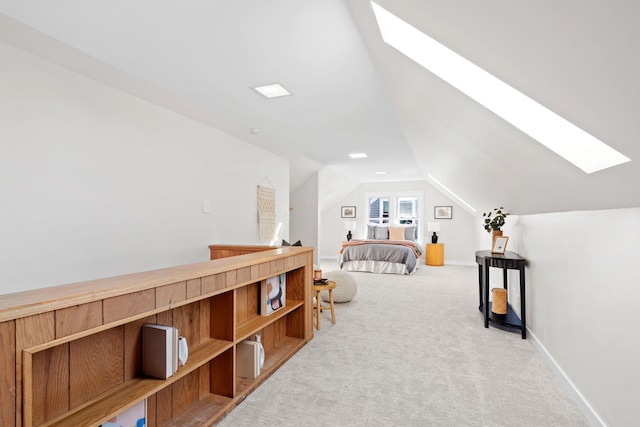 carpeted bedroom featuring vaulted ceiling with skylight