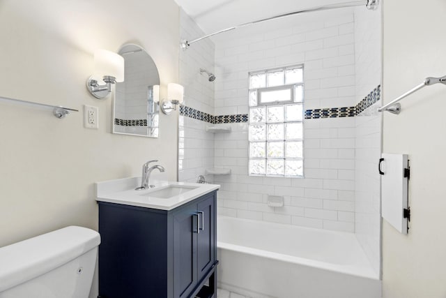 full bathroom featuring vanity, tiled shower / bath combo, and toilet