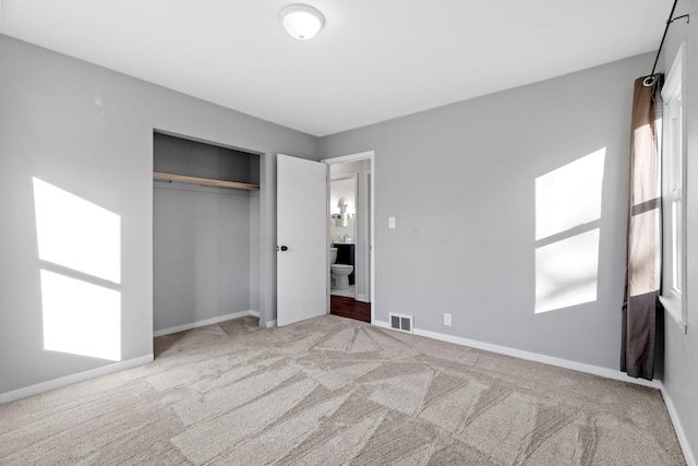 unfurnished bedroom featuring a closet and light carpet