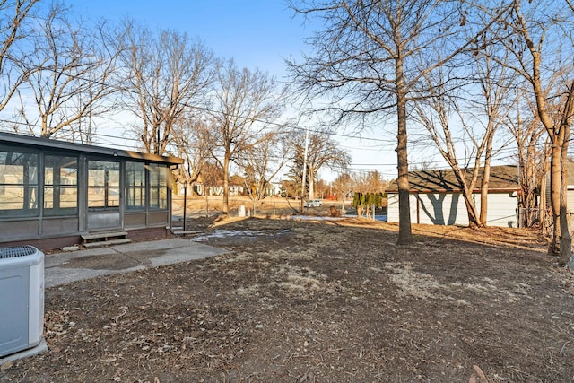 view of yard featuring a sunroom and central AC unit