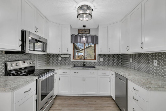 kitchen featuring white cabinets, appliances with stainless steel finishes, and sink