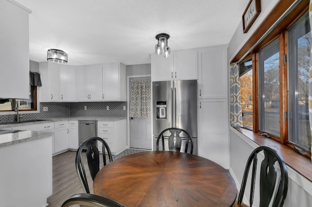 dining space with plenty of natural light, light hardwood / wood-style floors, and sink