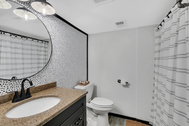 bathroom with wood-type flooring, vanity, and toilet