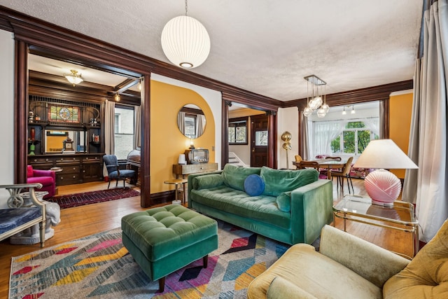 2742 Dupont Ave S, Minneapolis, MN 55408 - living area featuring ornamental molding, a chandelier, stairs, wood finished floors, and a textured ceiling