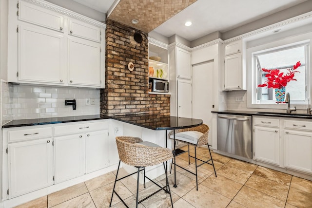 2742 Dupont Ave S, Minneapolis, MN 55408 - kitchen with stainless steel appliances, white cabinetry, decorative backsplash, dark countertops, and light tile patterned floors