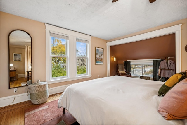 2742 Dupont Ave S, Minneapolis, MN 55408 - bedroom with wood-type flooring, multiple windows, and a textured ceiling