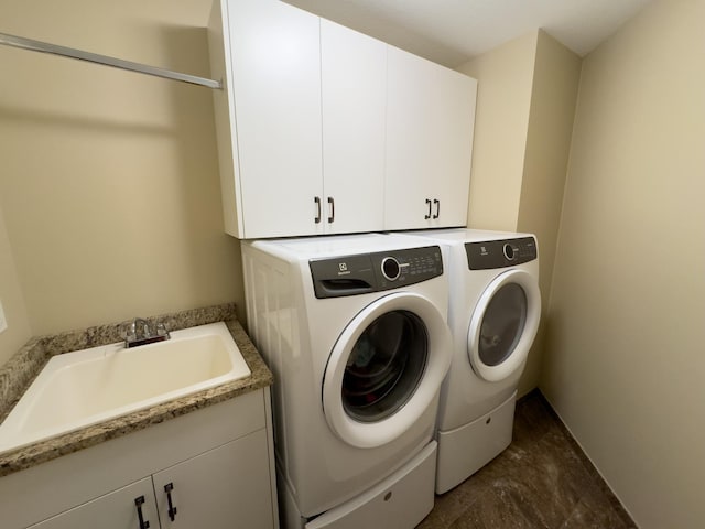 washroom featuring cabinets, sink, and separate washer and dryer