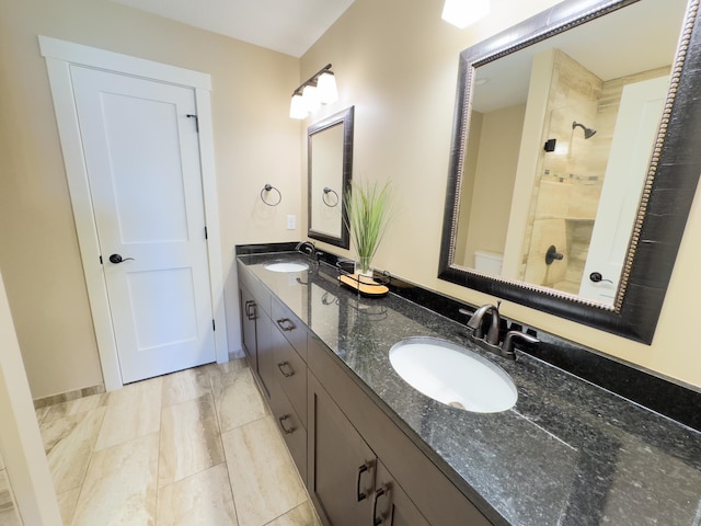 bathroom with vanity and a tile shower