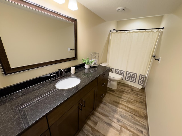 bathroom with vanity, curtained shower, toilet, and wood-type flooring