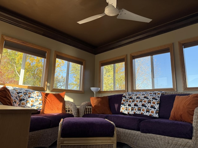 living room with ornamental molding and ceiling fan