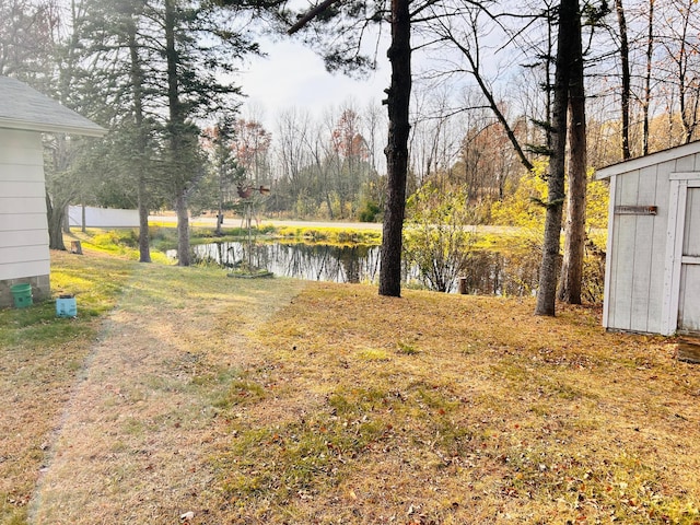 view of yard featuring a water view and a storage unit