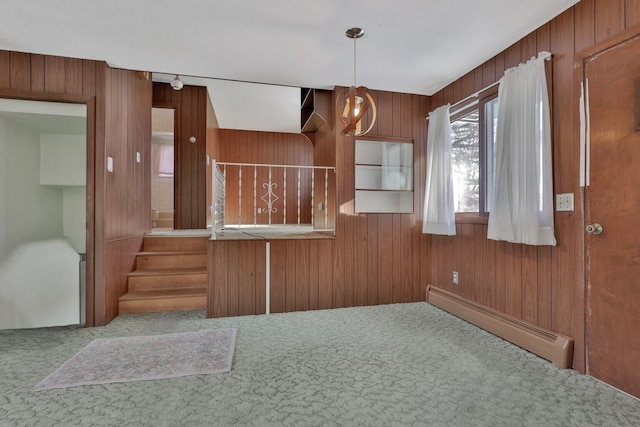 interior space featuring a baseboard heating unit, wooden walls, and carpet