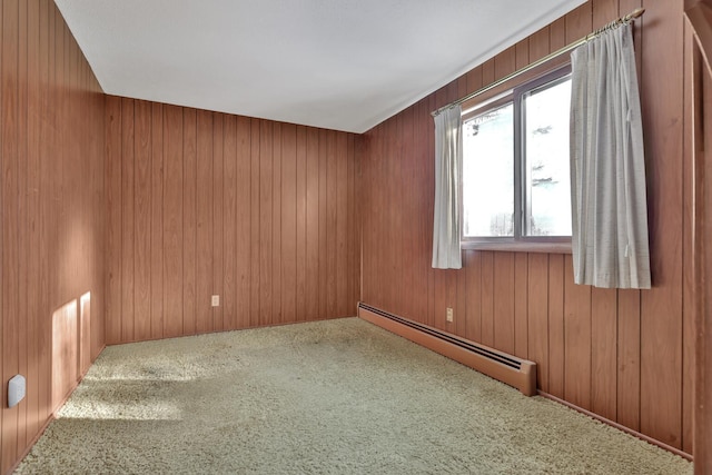 empty room with wood walls, carpet floors, and baseboard heating