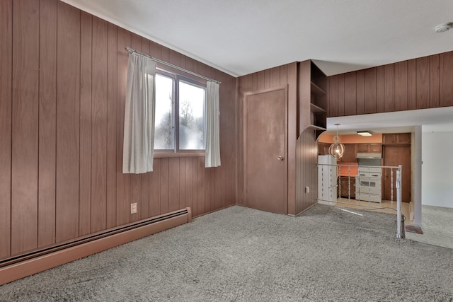 unfurnished living room featuring wood walls, carpet flooring, and a baseboard heating unit