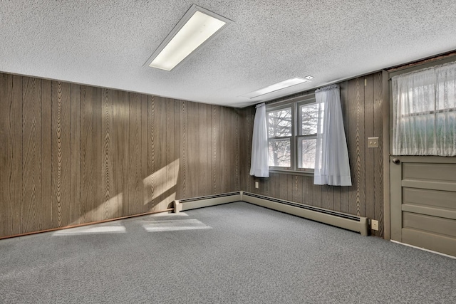 empty room with wood walls, carpet flooring, and a textured ceiling