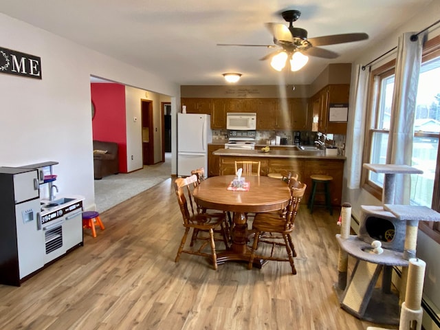 dining space with sink, ceiling fan, and light hardwood / wood-style flooring