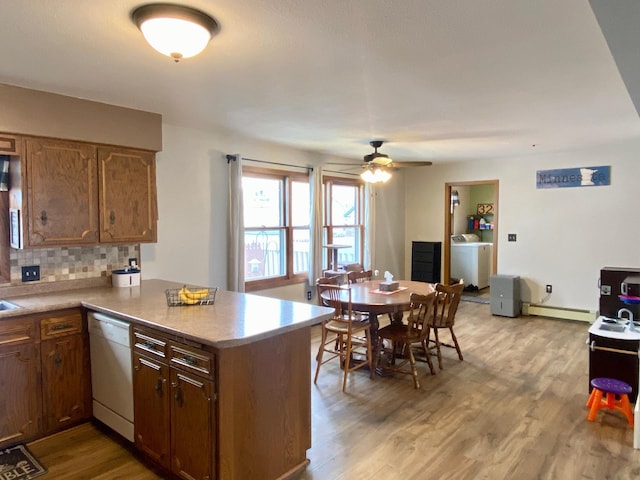 kitchen featuring light hardwood / wood-style floors, kitchen peninsula, white dishwasher, and a baseboard radiator