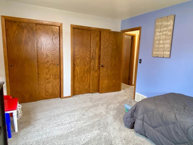 carpeted bedroom with multiple closets