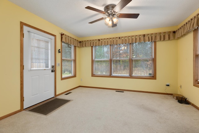 carpeted entrance foyer featuring a textured ceiling and ceiling fan