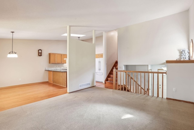 unfurnished living room featuring light hardwood / wood-style floors and lofted ceiling