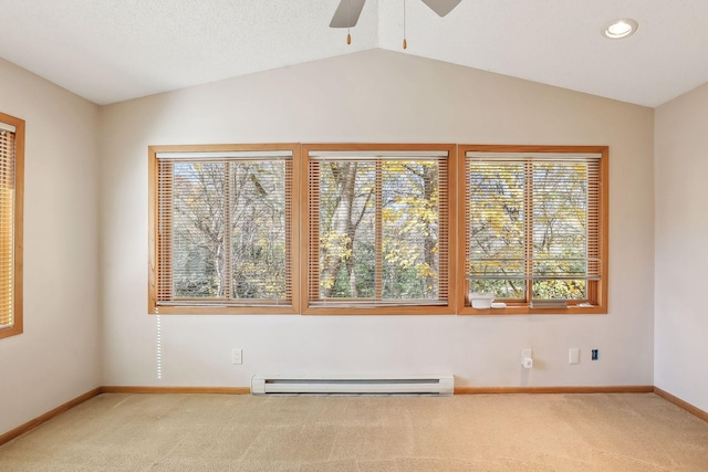 carpeted spare room with lofted ceiling, baseboard heating, ceiling fan, and a wealth of natural light