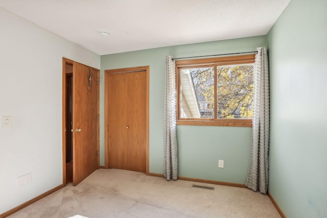 carpeted bedroom with a textured ceiling and a closet