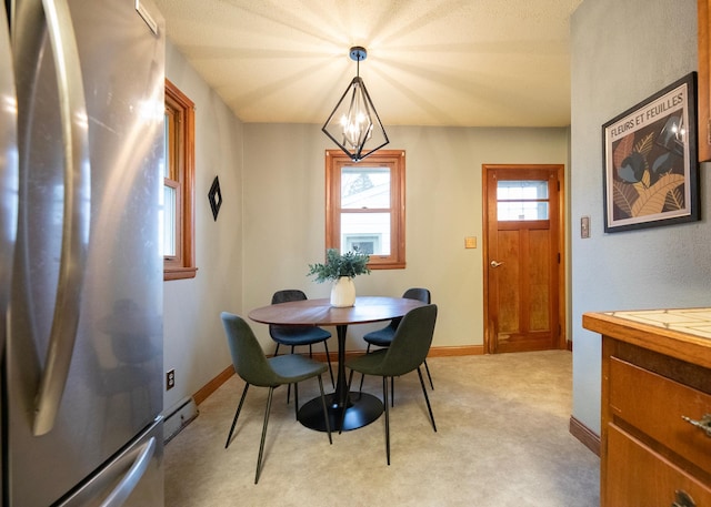 dining space with a notable chandelier, light colored carpet, and a baseboard radiator