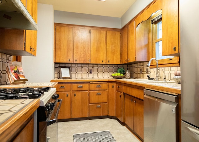 kitchen with dishwasher, white gas stove, sink, tasteful backsplash, and tile counters