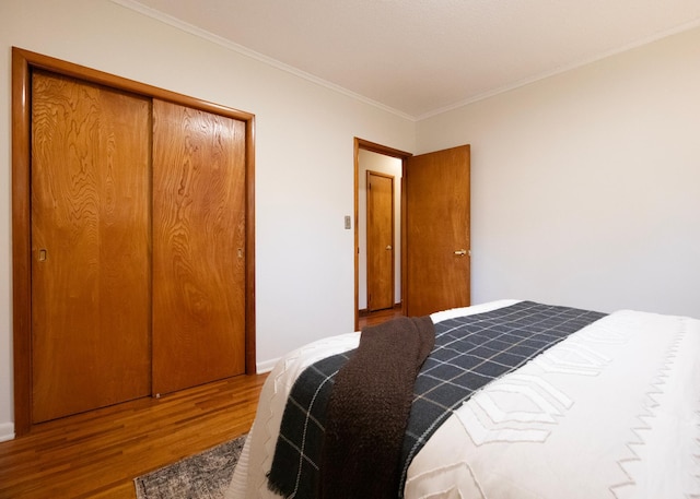 bedroom featuring a closet, hardwood / wood-style floors, and ornamental molding