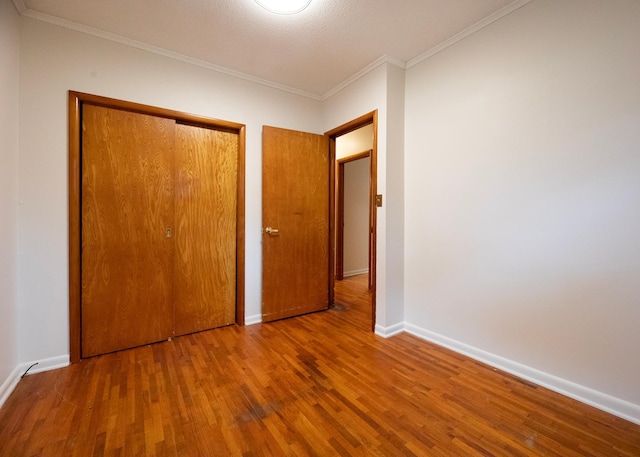 unfurnished bedroom featuring hardwood / wood-style flooring and crown molding