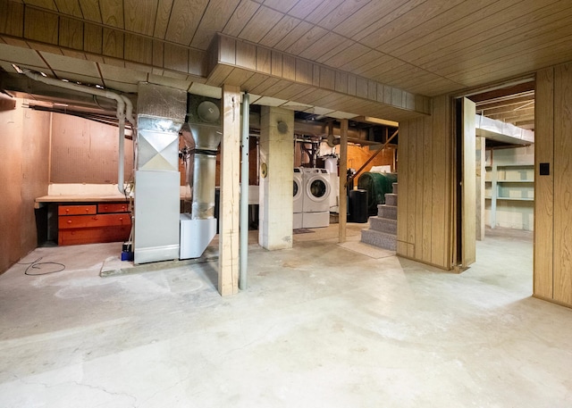 basement featuring washer and clothes dryer, wood walls, wood ceiling, and heating unit