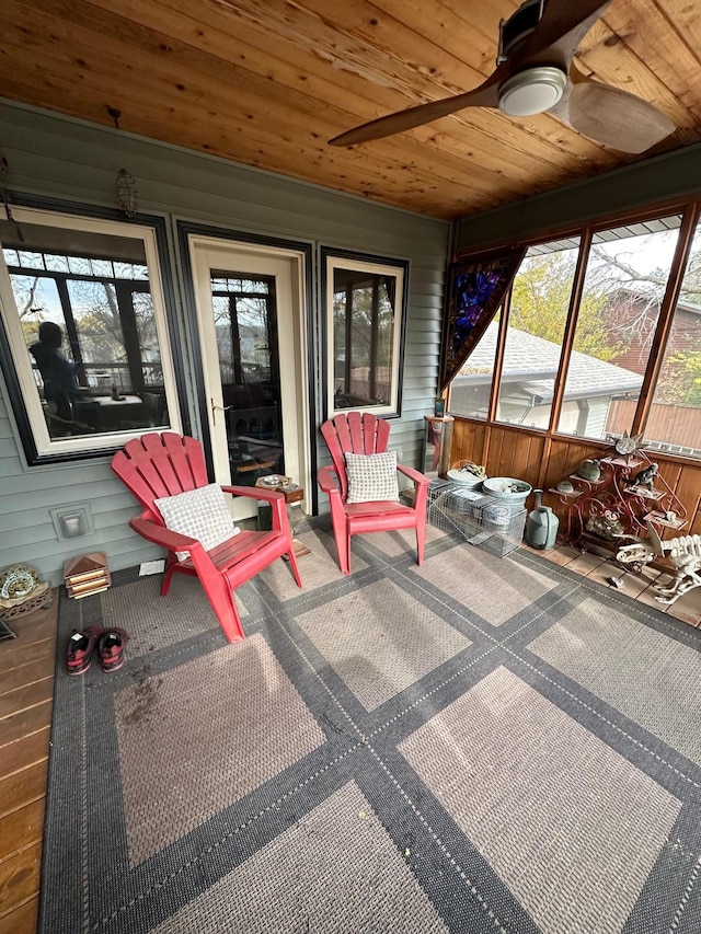 sunroom / solarium featuring a healthy amount of sunlight, ceiling fan, and wooden ceiling