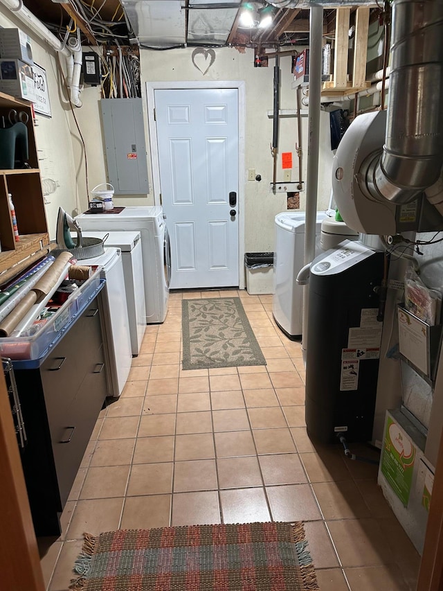 laundry room with light tile patterned floors, electric panel, and washing machine and clothes dryer