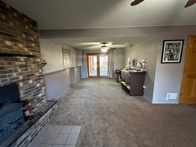 unfurnished living room with light carpet, french doors, and a textured ceiling