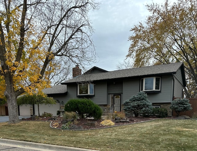 bi-level home with a front lawn and a garage