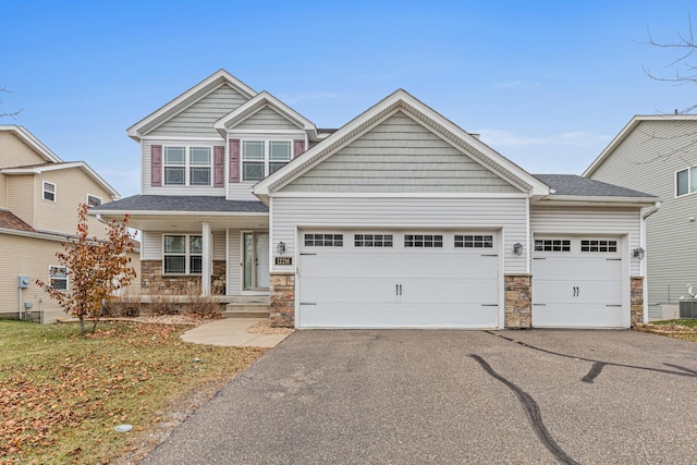 craftsman-style house featuring a garage and central air condition unit