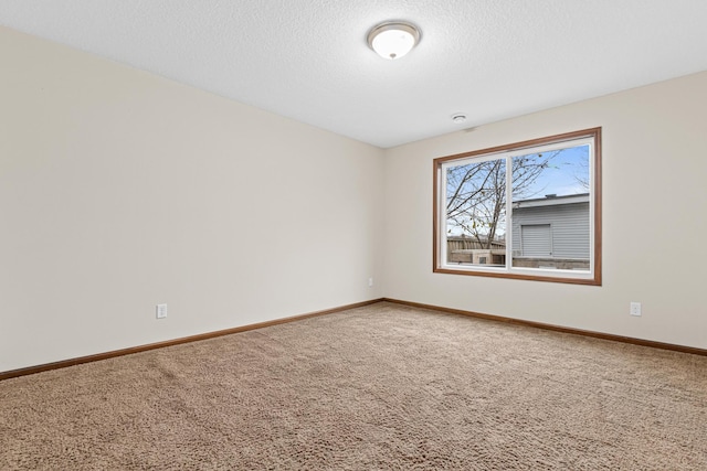 unfurnished room with carpet and a textured ceiling