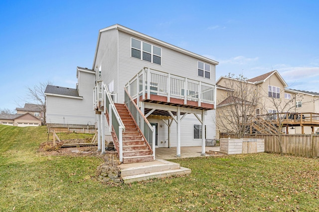 rear view of property featuring a lawn, a patio, and a deck