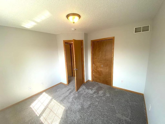 unfurnished bedroom with a closet, a textured ceiling, and carpet flooring