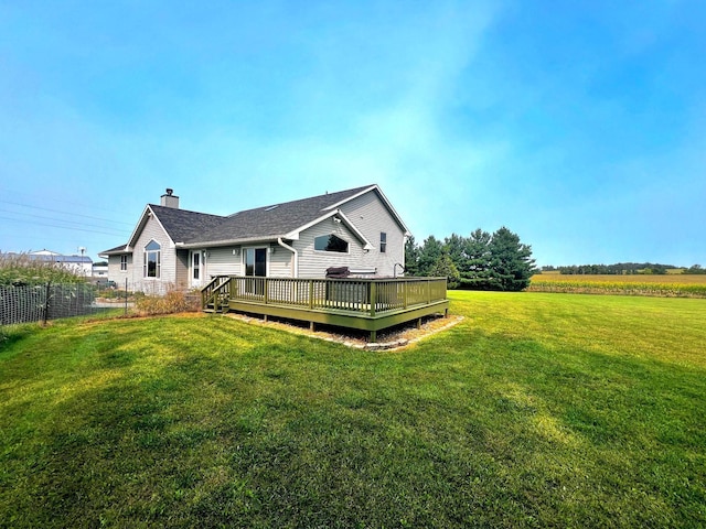 rear view of house featuring a lawn and a deck