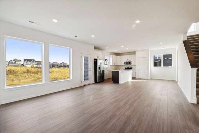 unfurnished living room with hardwood / wood-style flooring and sink