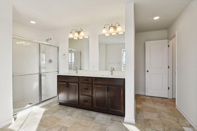 bathroom with a shower with door and vanity