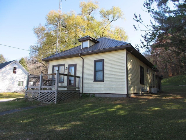 exterior space featuring a front yard, a deck, and central air condition unit