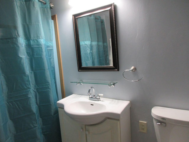 bathroom with vanity, curtained shower, and toilet