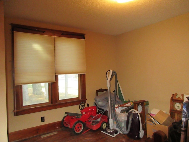 misc room featuring a textured ceiling and hardwood / wood-style flooring