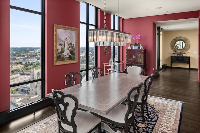 dining space featuring a wealth of natural light, a notable chandelier, and dark hardwood / wood-style flooring