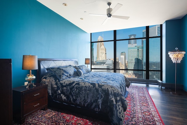 bedroom with expansive windows, dark wood-type flooring, and ceiling fan