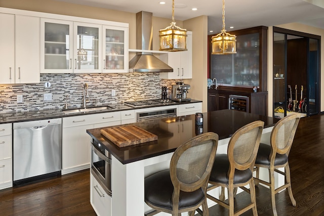 kitchen featuring stainless steel appliances, white cabinetry, hanging light fixtures, sink, and dark wood-type flooring