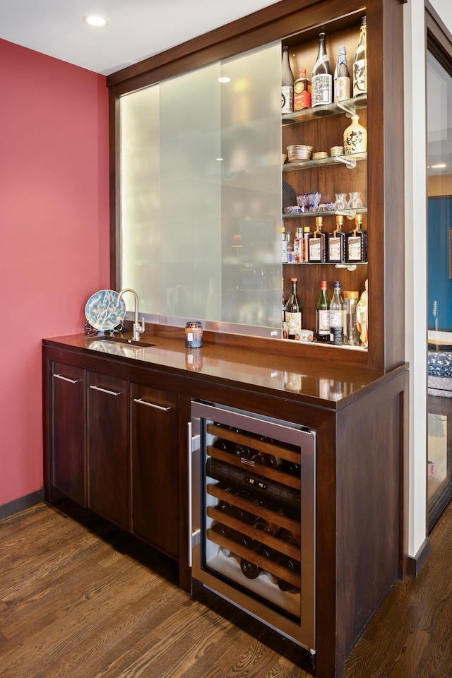 bar featuring dark wood-type flooring, beverage cooler, and sink